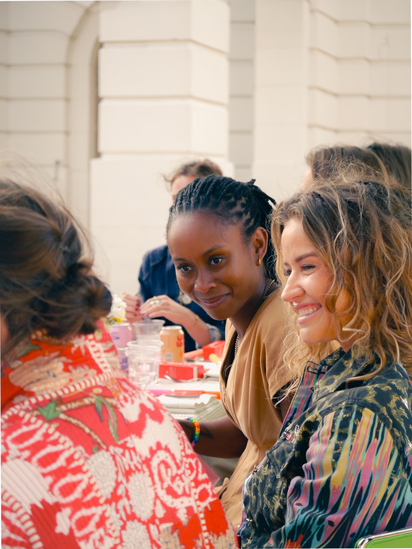 Women of different ages gathered around a table at a her.arca event